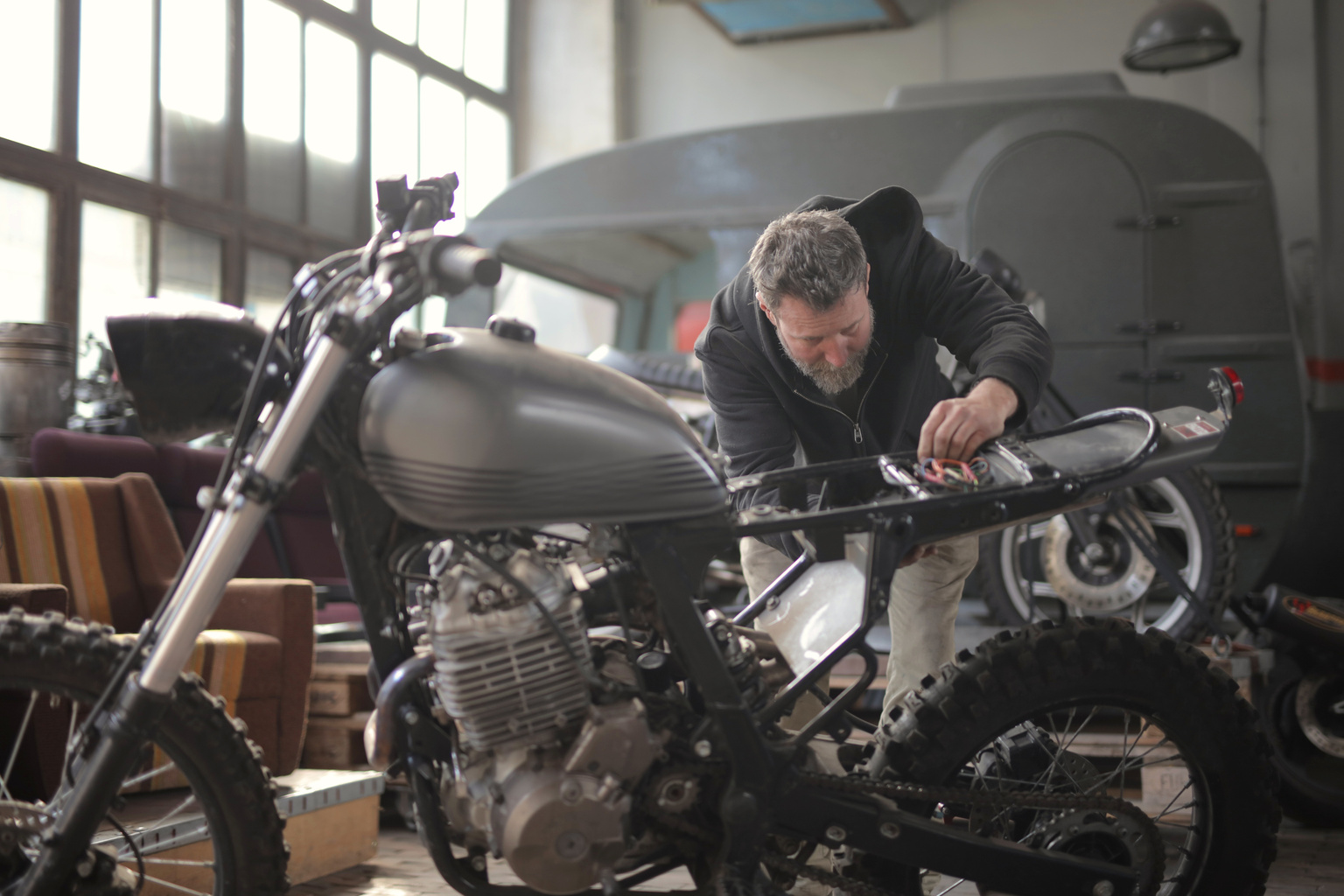 Man in Black Jacket Standing Near Black Motorcycle