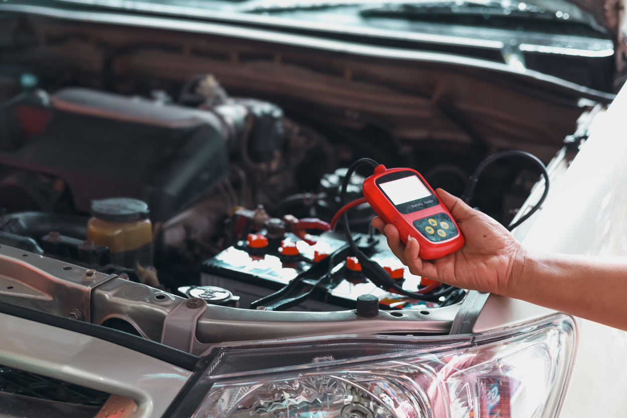 Mechanic Using Car Battery Performance Meter